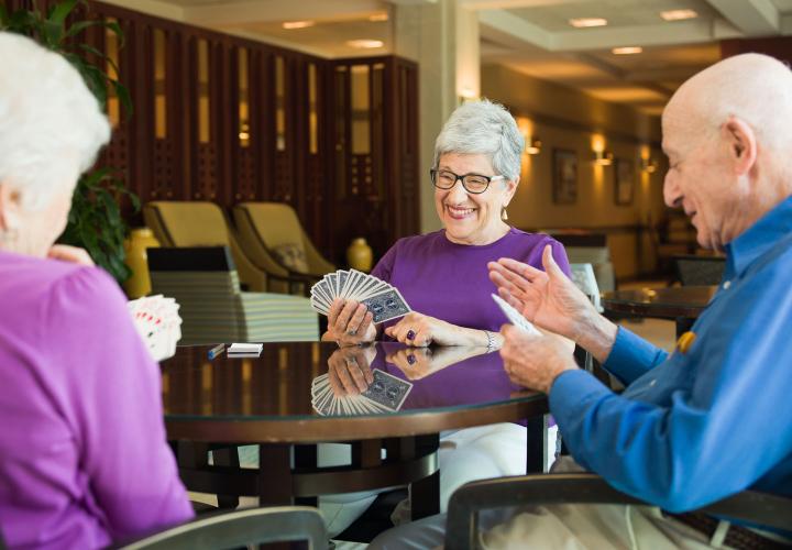 A group of Orchard Cove residents play cards in one of many common spaces for games.