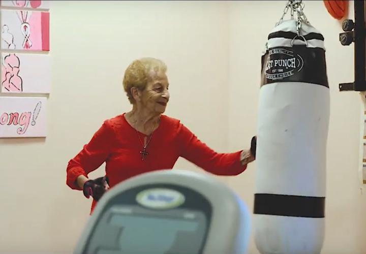 Jack Satter House resident Marge Marino punches a punching bag in the community's fitness center.