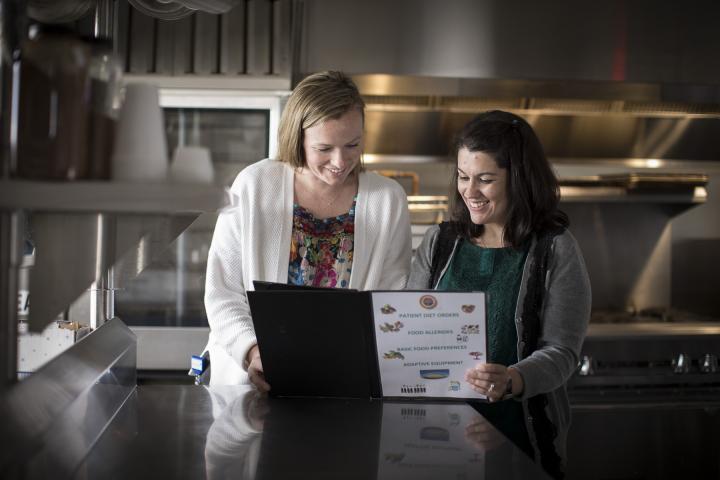 A dietetics intern and dietitian review a set of patient orders in a kitchen at Hebrew Rehabilitation Center in Boston.