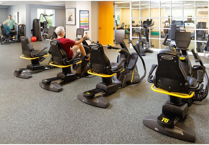 Orchard Cove's fitness center bustles with activity as residents use the equipment and talk with a fitness consultant.