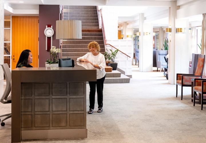 Front-desk receptionist helps a resident.