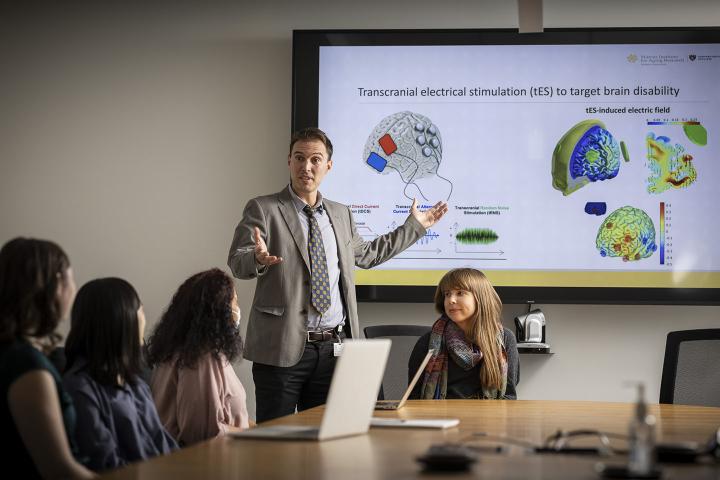 A senior researchers discusses his research with junior researchers.