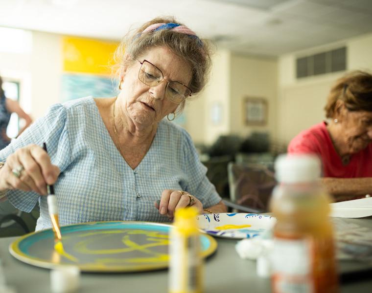 Two female residents participate in an art program.