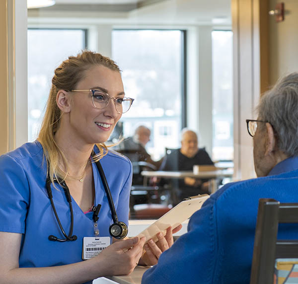 a female medical professional consults with a male patient in a comfortable, public setting